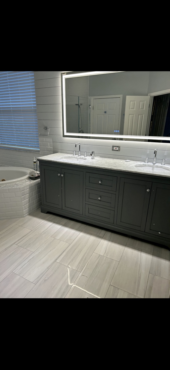 Double vanity, illuminated mirror, and coordinated tile finishes